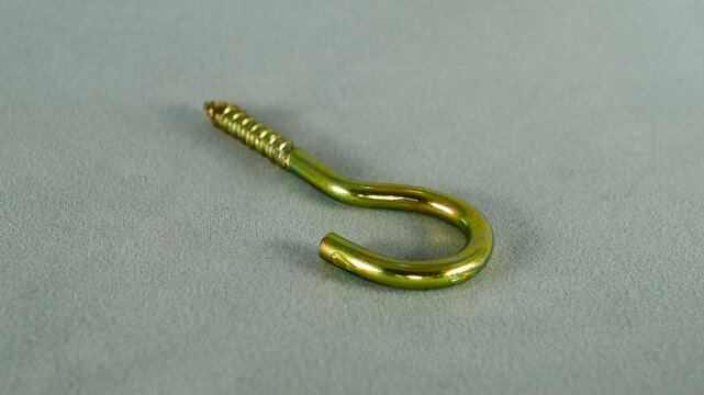 Yellow python screw. Screw with hook-shaped back. Focus is on the front.