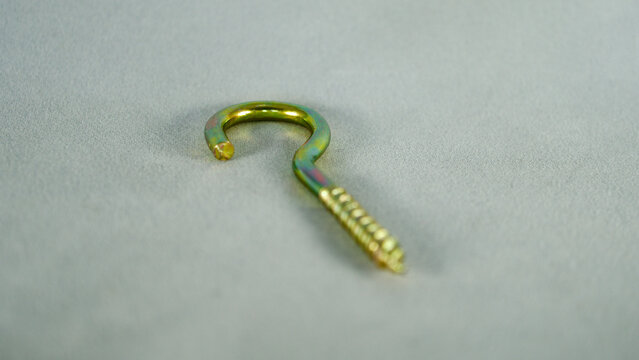 Yellow python screw. Screw with hook-shaped back. Focus is on the front.