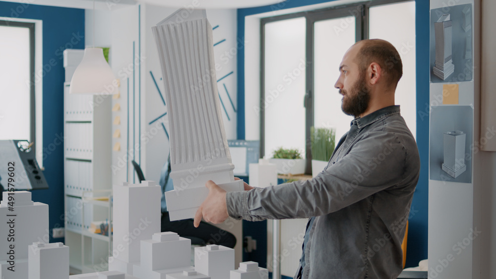 Poster man architect analyzing building model and maquette to design urban property. architectural worker d