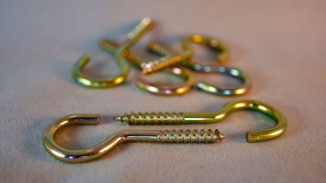 Yellow python screw. Screw with hook-shaped back. Focus is on the front.