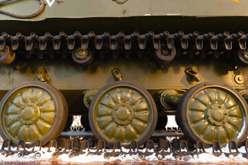 Wheels of military tracked vehicles close-up. Tank or infantry vehicle side view.