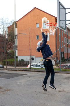 Teenage boy scoring basketball shot