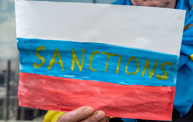 poster in male hands with text sanction for Russia