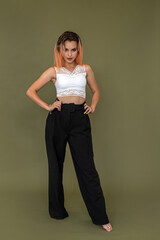 young european woman in stylish white top and black pants posing in full growth isolated