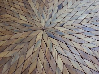Surface of a placemat or sousplat, wooden with geometric designs.