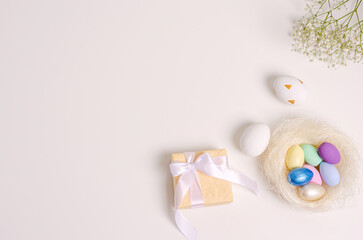 Fototapeta na wymiar Easter colored eggs in a physalis nest, gift boxes, hepsophila branch on a white background