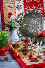 Traditional Azerbaijan spring holiday Novruz tray with semeni - wheat grass, pakhlava, shekerbura,badambura,mutaki,gogal,flowers,dry fruits,spring flowers.