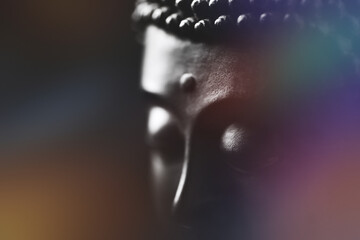 Meditating Buddha Statue on black background. Soft focus. Close up. Copy space.