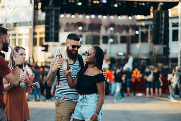 Beautiful couple drinking cocktails and having fun at music festival