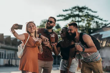 Gartenposter Group of friends taking selfie with a smartphone on a music festival © Zamrznuti tonovi