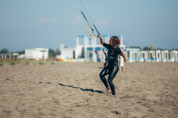 Woman using control bar to lift her kite up for kitesurfing