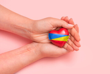Hand holding a heart with Ukrainian national colors