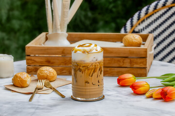 Caramel iced coffee glass cup on marble table