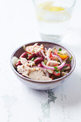 Salad with tuna and cherry tomatoes. Wooden background. Close up. Copy space.
