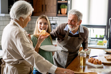 Affectionate senior grandparents in love with children in kitchen