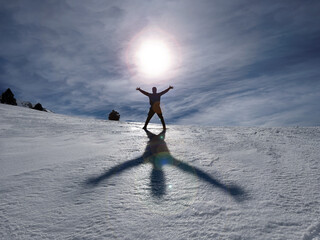 sunset in the snowy mountains and an enthusiastic person open their arms