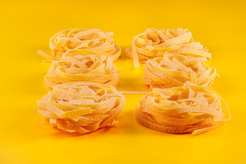 Pasta in the form of a nest on a yellow background