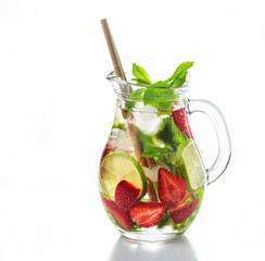 Jug of tasty cold detox fruits infuse water with ice, strawberry, mint and lime isolated on white...