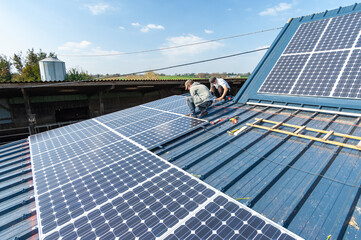 Fototapeta Energie renouvelable. Pose de panneaux photovoltaiques sur le toit d'un batiment agricole ancien obraz