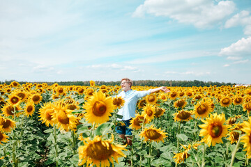 Woman in the sunflowers field. Summertime. Young beautiful woman standing in sunflower field.  