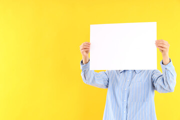 Woman with blank banner on yellow background