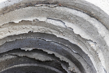 Reinforced concrete rings and slabs for wells on the construction site. Preparation for the device of underground wells and communications. Close-up.
