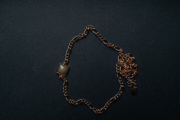 Fototapeta na wymiar geometrical pendant and golden chain. jewelry on black background. High quality photo