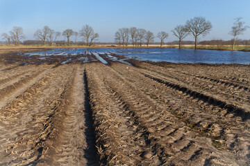 Muddy field after bad weather, flooded after heavy rains in winter