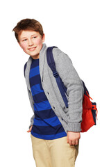 Leaving for school. A young boy standing with his hands in his pockets.