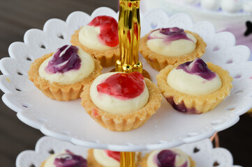 Freshly baked cheese tarts with different flavor on tray.