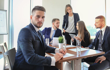 Businessman with colleagues in the background in office