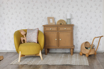 Children's room interior. Armchair for kid standing in white room interior with cabinet and toys
