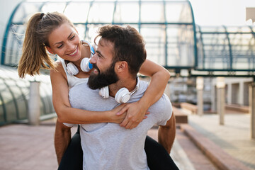 Happy runner couple exercising outside as part of healthy lifestyle. People sport running concept
