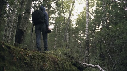 Fototapeta premium Traveler photographing scenic view in forest. One caucasian woman shooting nice magic look. Girl take photo video on dslr mirrorless camera. Professional photographer travel with backpack. Outdoor.