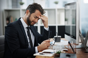 The pressures of the day are driving him insane. Shot of a young businessman looking stressed out...