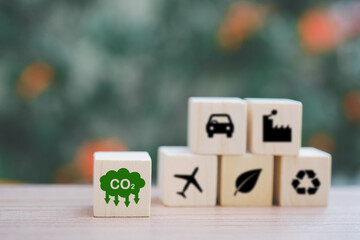 green CO2 emission reduction icon on wooden cubes with blur blocks for  CO2 emission ,green industries business. net zero emissions. renewable energy, sustainable technology, ecology solutions concept
