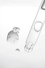 Pipette with cosmetic product in water with bubbles.
