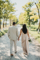 Newlywed romantic wedding couple walking. The bride and groom walk holding hands.