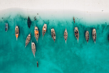 Top view or aerial view of Beautiful crystal clear water and white beach with long tail boats in summer of Zanzibar island - obrazy, fototapety, plakaty