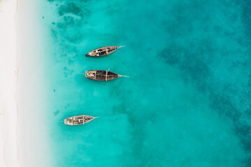 Top view or aerial view of Beautiful crystal clear water and white beach with long tail boats in summer of Zanzibar island