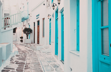 traditional narrow street in Mykonos with blue doors and white walls