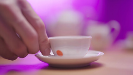 Person hand pick up vintage tea cup close-up