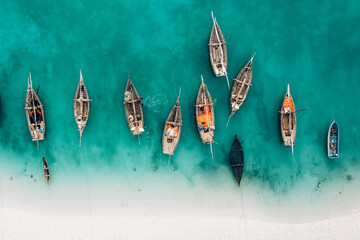 Draufsicht oder Luftaufnahme des schönen kristallklaren Wassers und des weißen Strandes mit Langschwanzbooten im Sommer der Insel Sansibar
