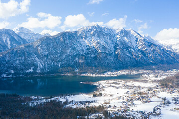 Aerial view. Winter Alpine lake Grundlsee. Embedded in the wonderful mountain massif of the Dead Mountains. Clear cold landscape with blue sky and cumulus clouds