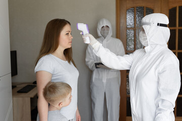 Doctor check patient body temperature using infrared forehead thermometer gun at home. Coronavirus,...