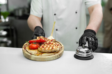 Cook with a ready-made dish with meat and vegetables on a wooden Board