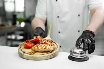 Cook with a ready-made dish with meat and vegetables on a wooden Board