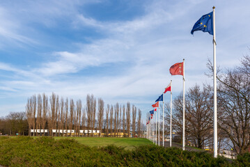 Masts with flags of Poland and European Union. Inscription: Nigdy wiecej wojny (in English: No more war) in background. Gdansk Westerplatte, Poland