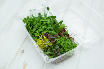 Assorted, a mix of various micro-greens in a transparent plastic box.