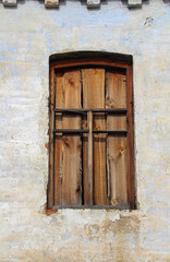 A window clogged with boards in an old abandoned building, close-up.
